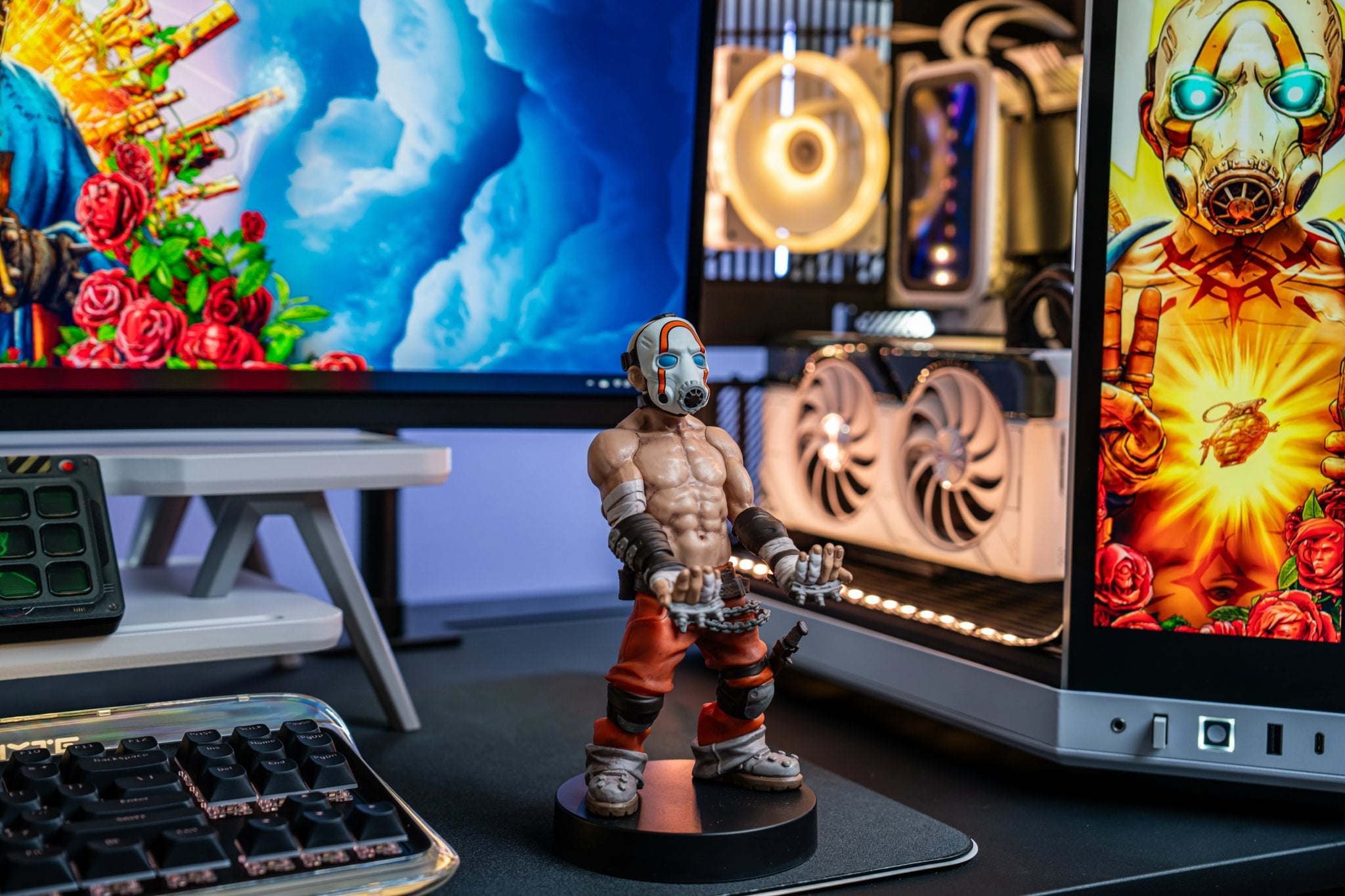 Borderlands Psycho Cable Guy figure displayed on a gaming desk with monitors showing Borderlands artwork and RGB lighting.